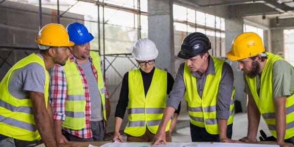 Construction team discussing blueprints on-site.