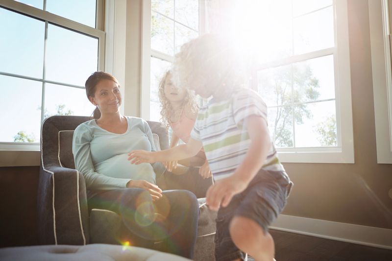 Shot of a pregnant woman spending time with her children at home