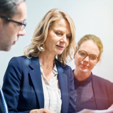 Three professionals engaged in a focused business discussion.