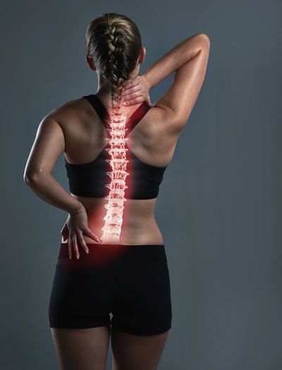 Woman grabbing her neck and back in pain