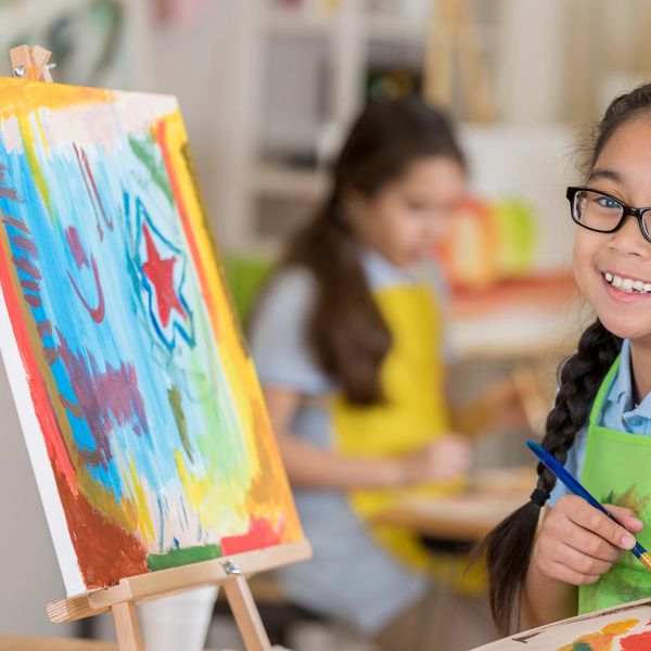 Two young girls painting in an art class.