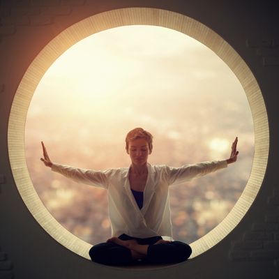 Woman meditating in a circular window with a serene city backdrop.