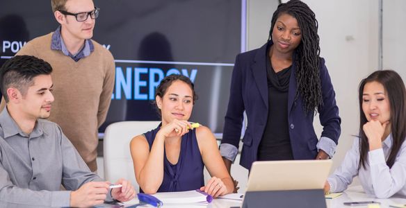 Group of professionals having a meeting around a laptop.