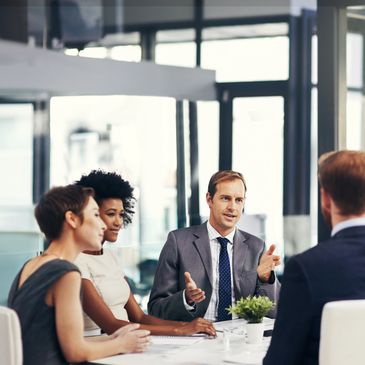 Four professionals engaged in a business meeting in a modern office.