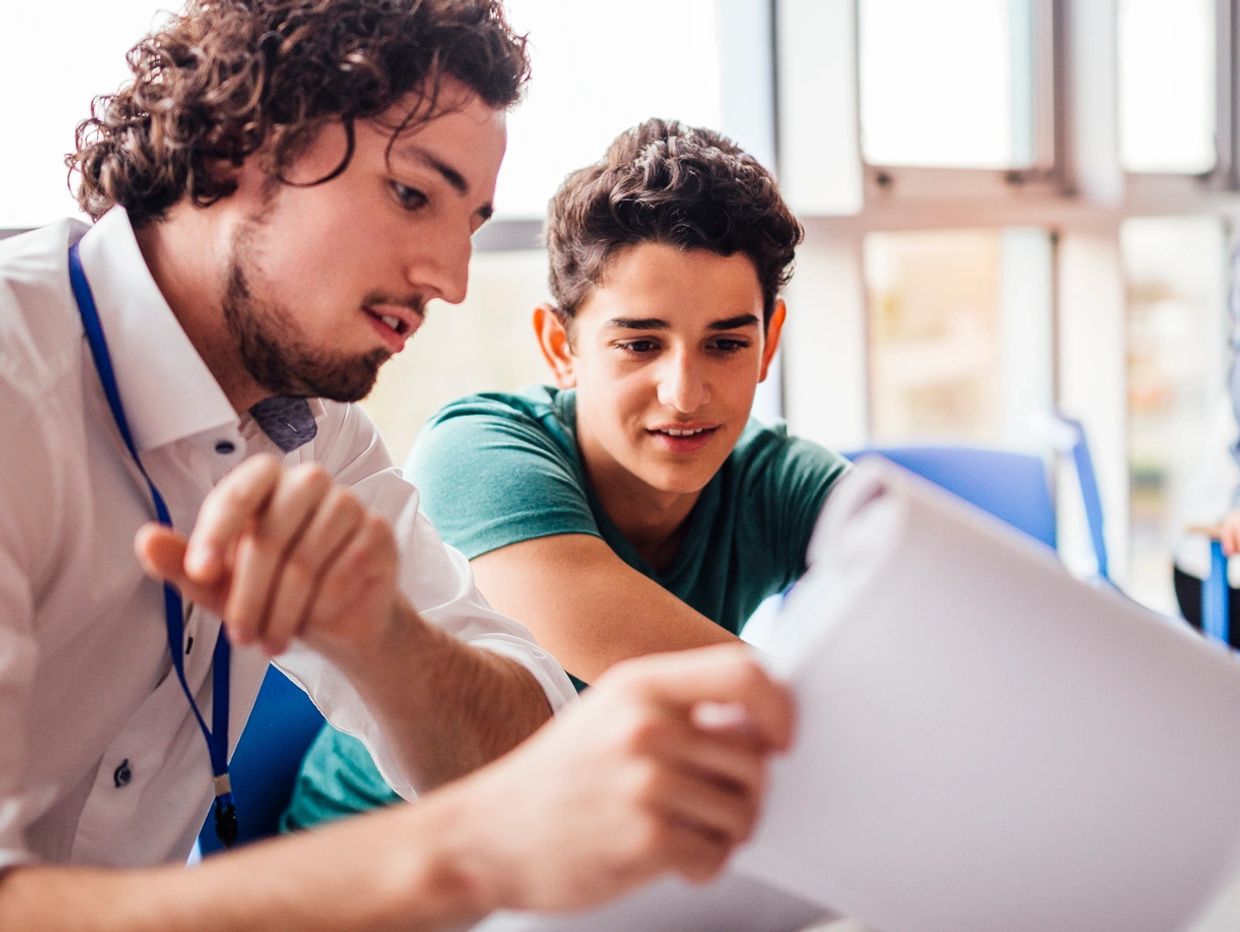 Two young men reviewing documents together.