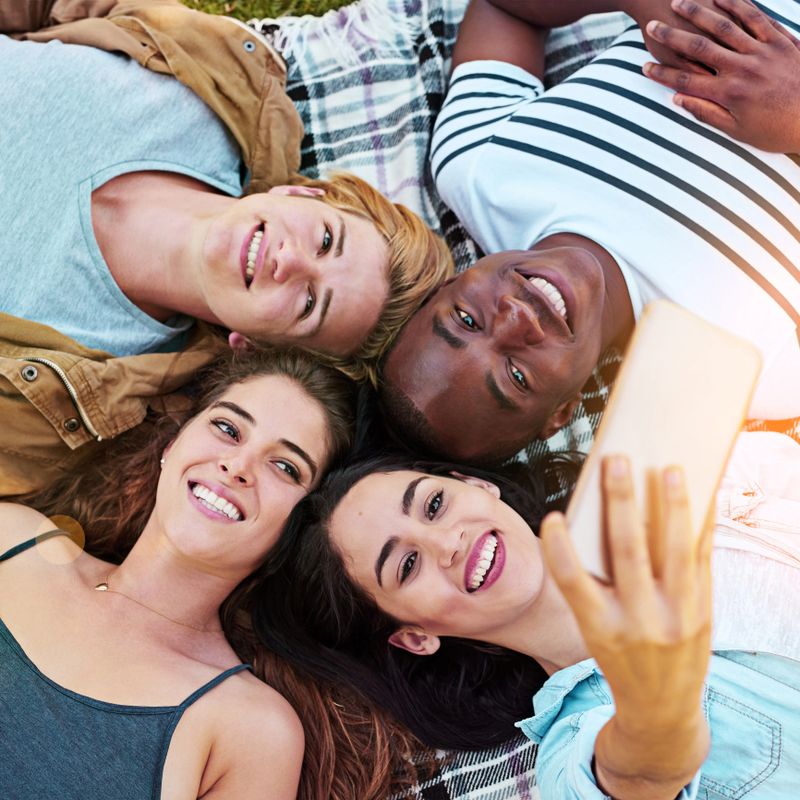 Shot of a group of young friends taking a selfie together outdoors
