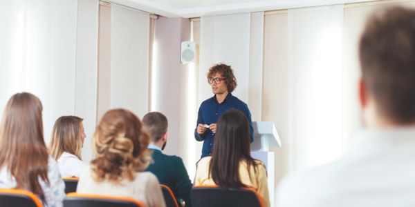 Un uomo parla davanti a un pubblico in una presentazione.