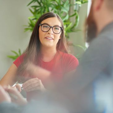 Young woman in glasses attentively listening during a conversation.