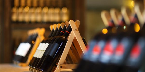 Wine bottles displayed on wooden racks in a cozy setting.