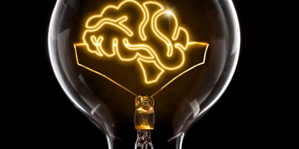 Light bulb filament shaped like a brain glowing.