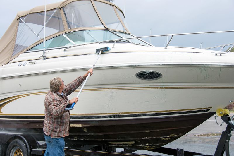 Caucasian man scrubbing boat