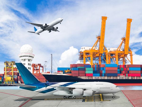Two airplanes near a cargo port with shipping containers and cranes.