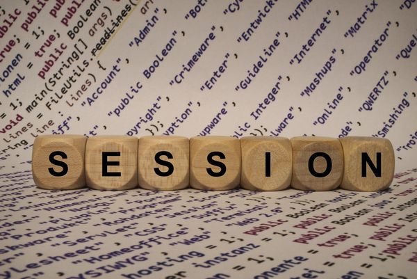 Wooden blocks spelling "SESSION" on a programming code background.