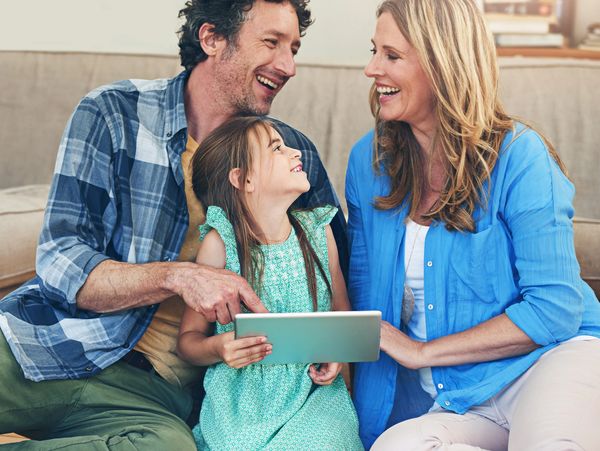 Happy family enjoying quality time together with a tablet.