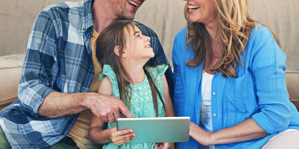 Happy family enjoying quality time together with a tablet.