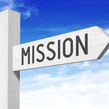 White directional sign with the word 'MISSION' against a blue sky.