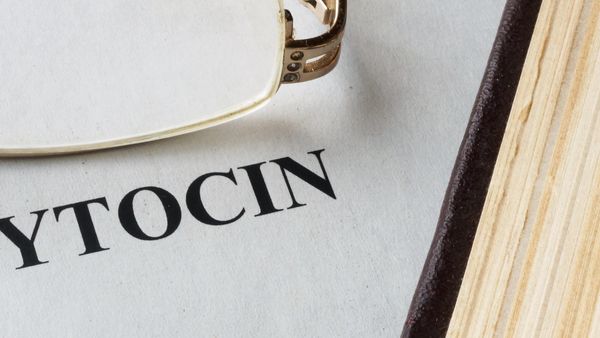 Close-up of the word "CYTOCIN" on paper next to a book and glasses.