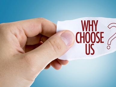 Hand holding paper with 'Why Choose Us?' text on blue background.