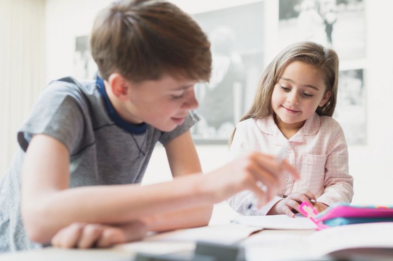 Brother helping sister with homework