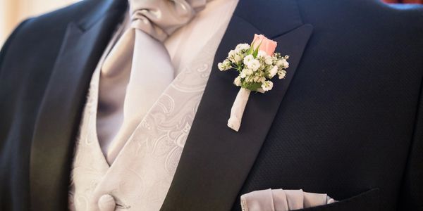 Close-up of a groom's boutonniere on a black tuxedo jacket.