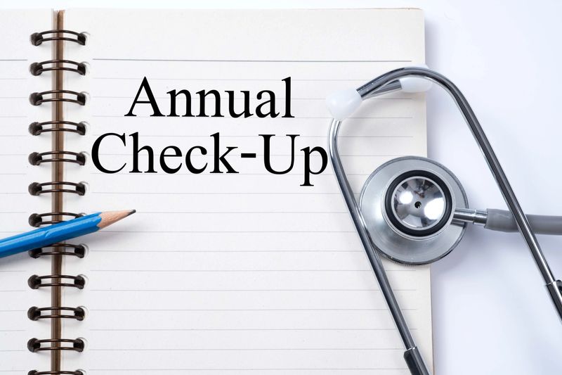 Stethoscope on notebook and pencil with Annual Check-Up words as medical concept.