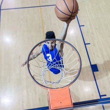 Young basketball player dunking a ball.