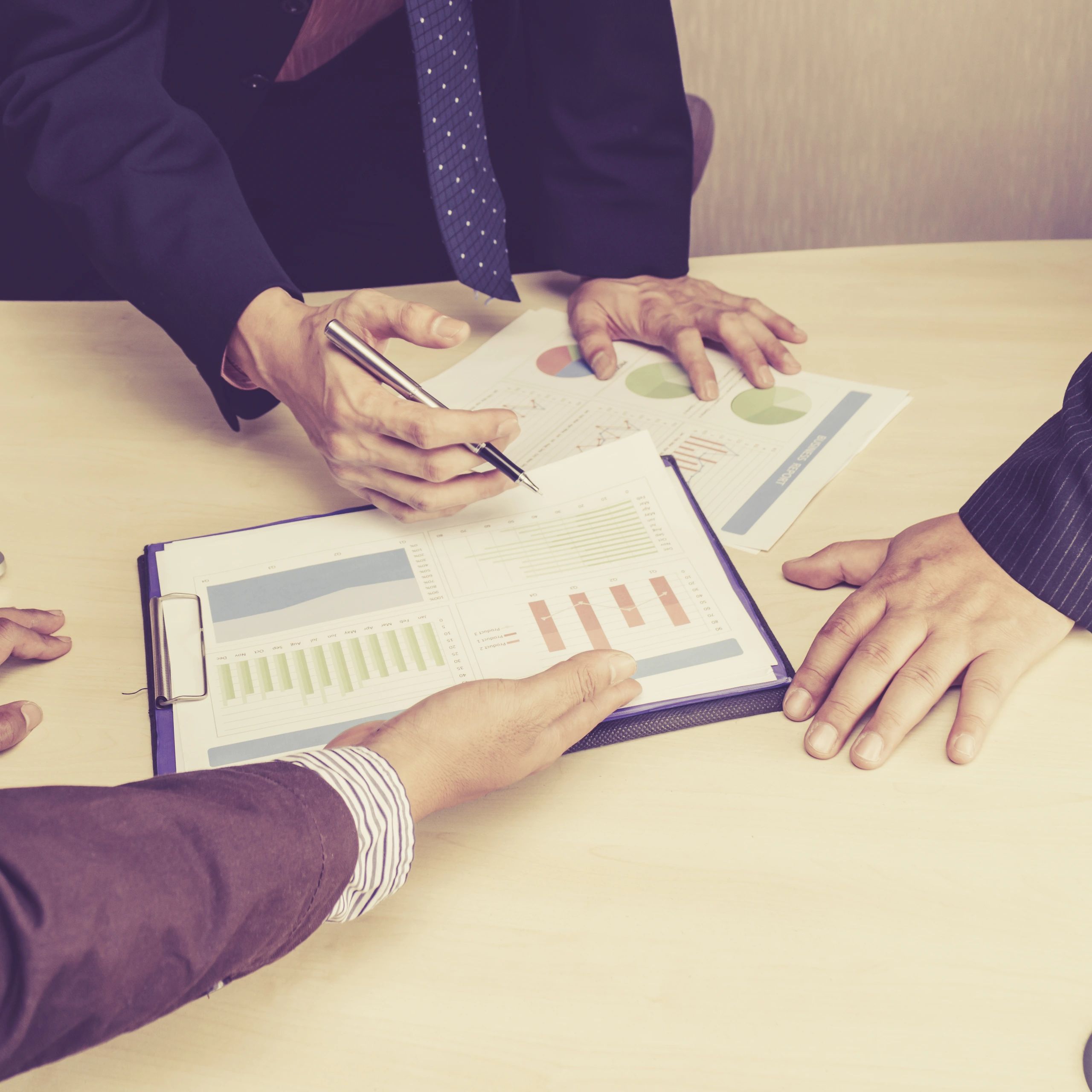 Business professionals discussing financial charts and data in a meeting.