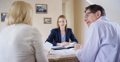 Couple consulting a professional woman at office.