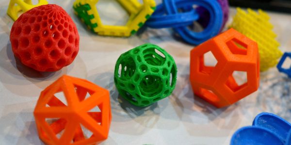 Colorful 3D-printed geometric shapes with intricate patterns on a white surface.
