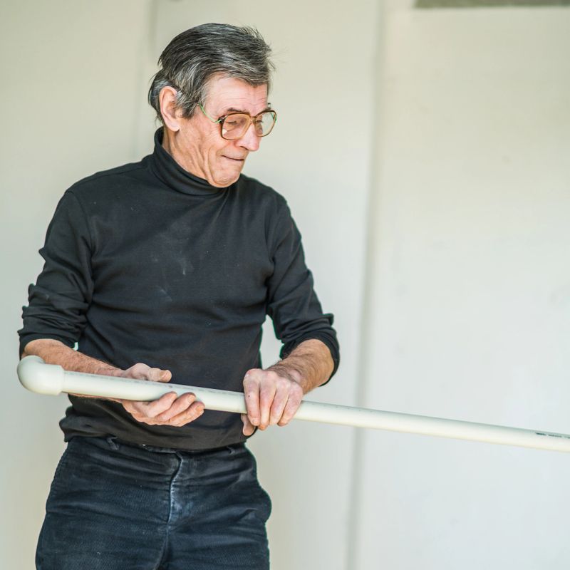 70-years-old active senior man, construction worker - plumber, working indoor for home renovation in the new residential apartment in Minsk, Belarus, Eastern Europe. New apartments in Belarus are purchasing in most cases without any finishing, and buyers doing the final stage of construction by his own expenses, sometimes by themself.
