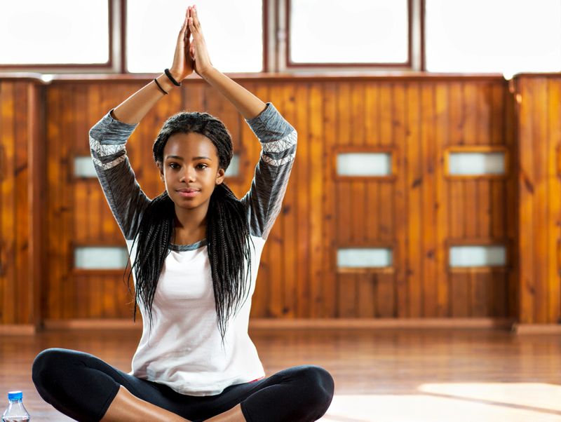 African cute girl is doing yoga, indoor.
