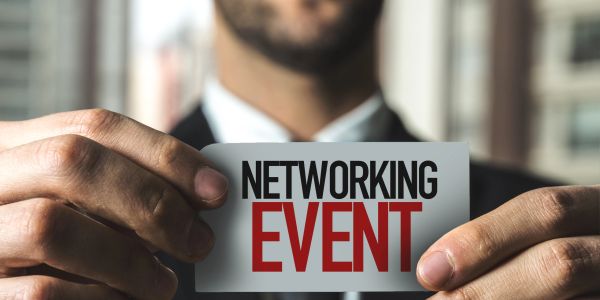 Person holding a card that says 'Networking Event'.
