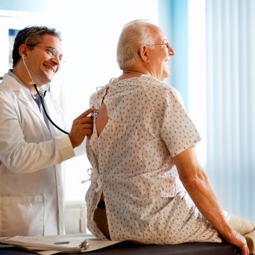 Doctor examining elderly patient with stethoscope.
