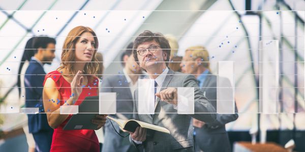 Business professionals discussing data charts in a modern office.