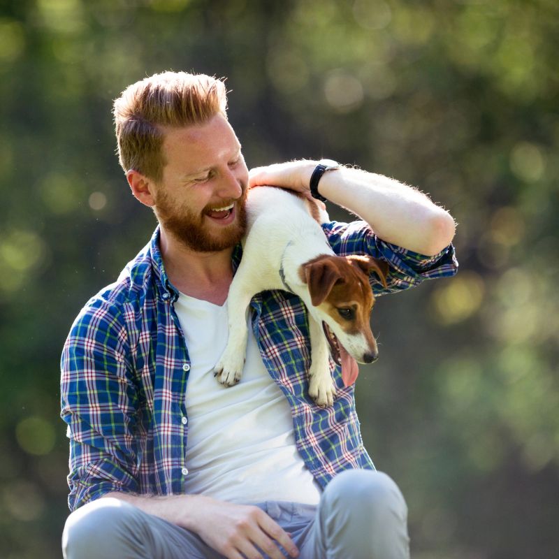 Shot of a handsome young man spending time with his dog in the park.