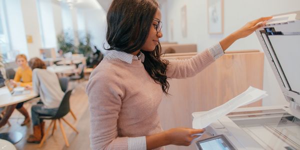 Woman using office copier to scan or copy documents.