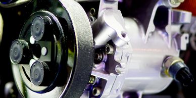 Close-up of a mechanical component with a belt and bolts.