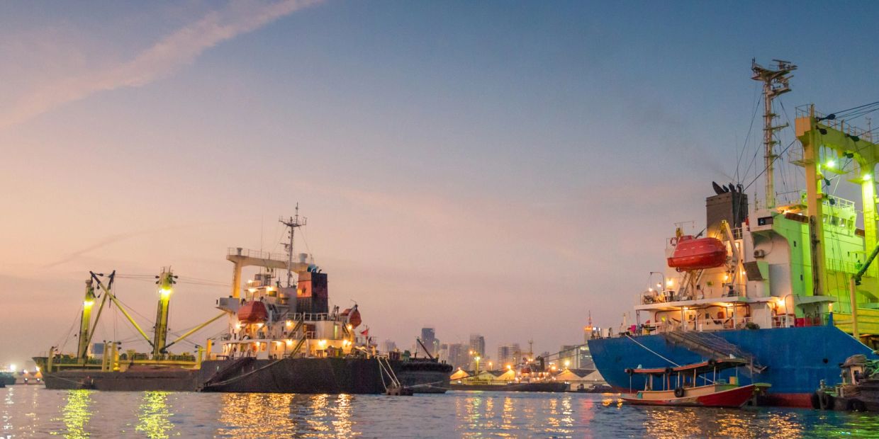 Ships docked at a harbor during sunset.