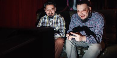 Two men playing video games together indoors.