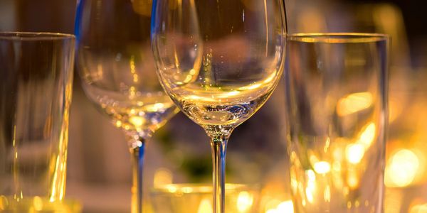 Close-up of empty wine glasses with warm lighting in the background.