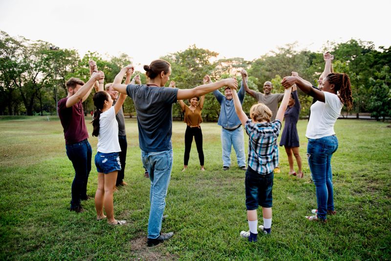 Group of people holding hand together in the park