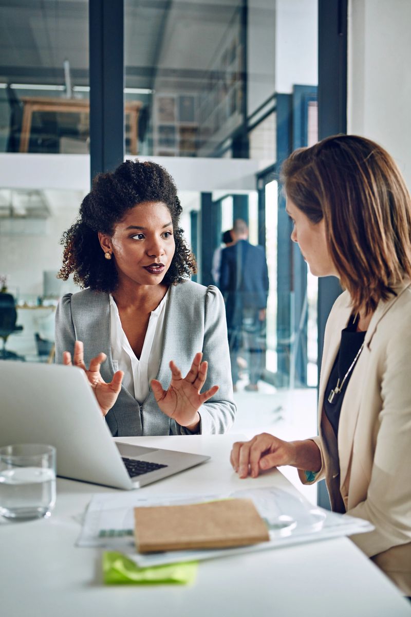 Cropped shot of two corporate businesswomen having a discussion in an office