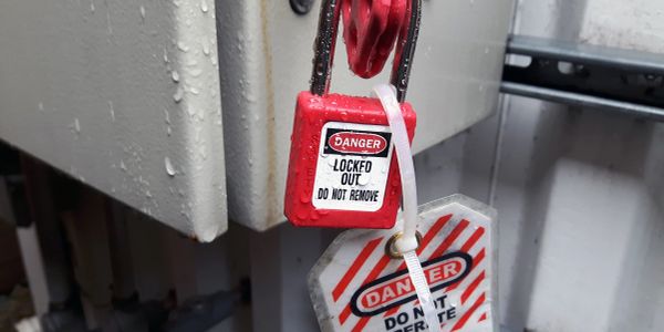 Red lockout padlock with danger warning tags.