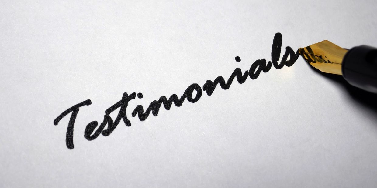 Fountain pen writing "Testimonials" on paper.