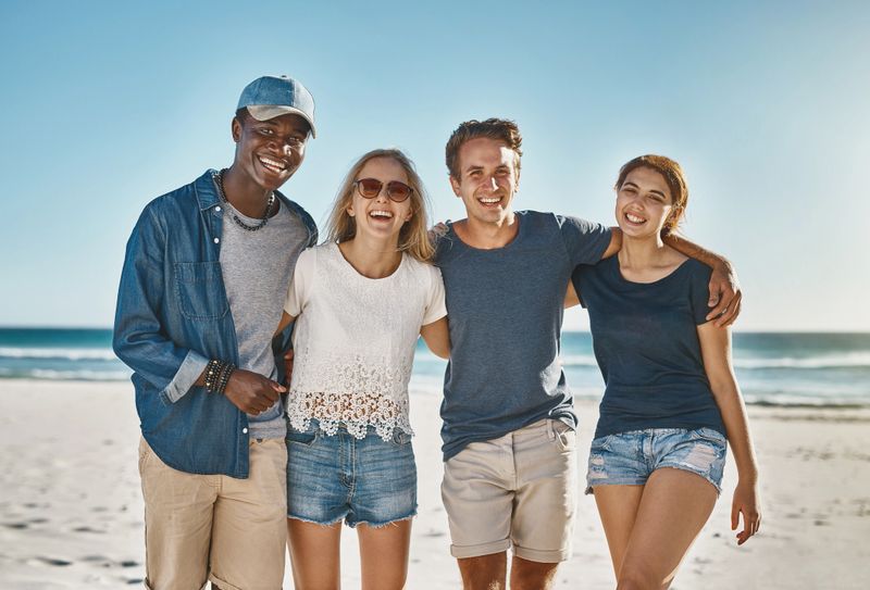 Portrait of a group of happy young friends posing on the beach together
