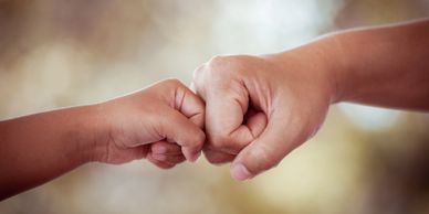 Volunteer agreement symbolized by a parent and child fist bumping at Cola Kids Consignment