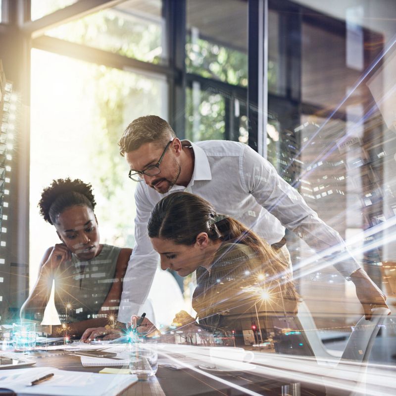 Multiple exposure shot of a group of businesspeople having a meeting in an office superimposed over a cityscape