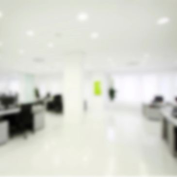 Blurred modern office interior with desks and chairs.