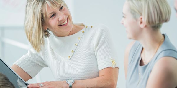 A two woman smiling with looking each other