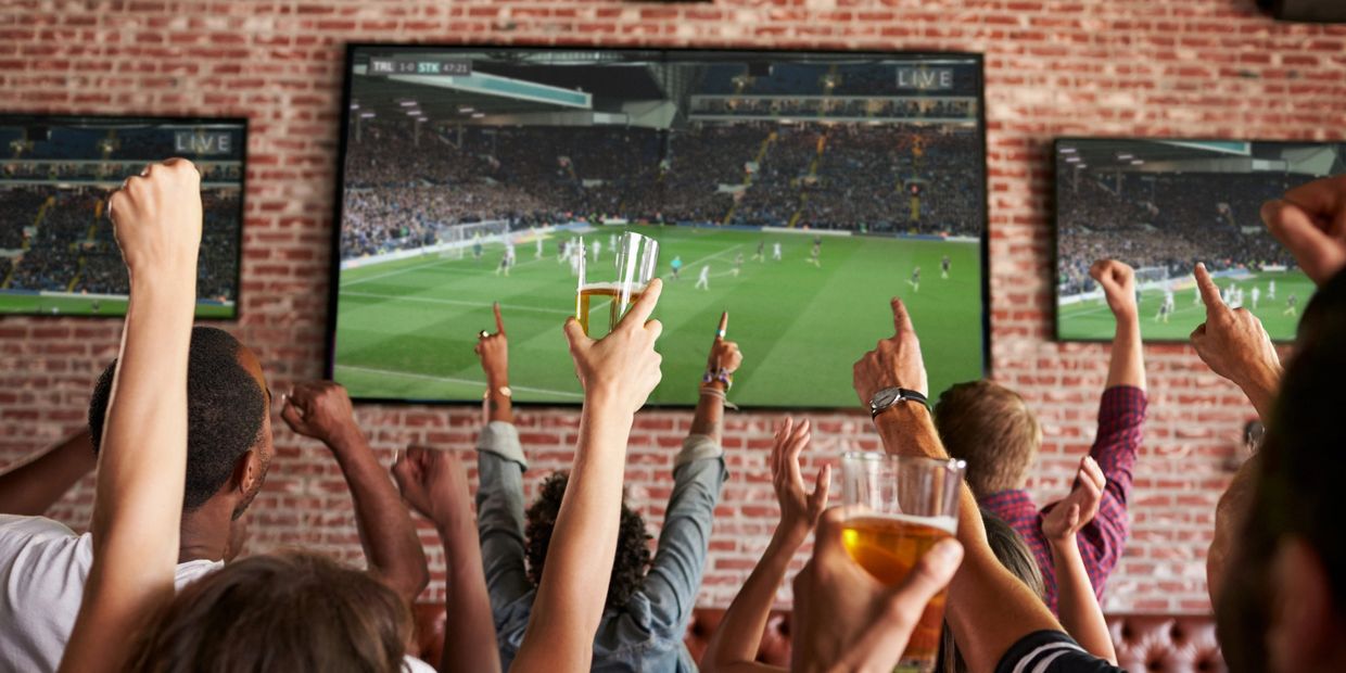 Sports bar with multiple televisions and fans cheering during a game